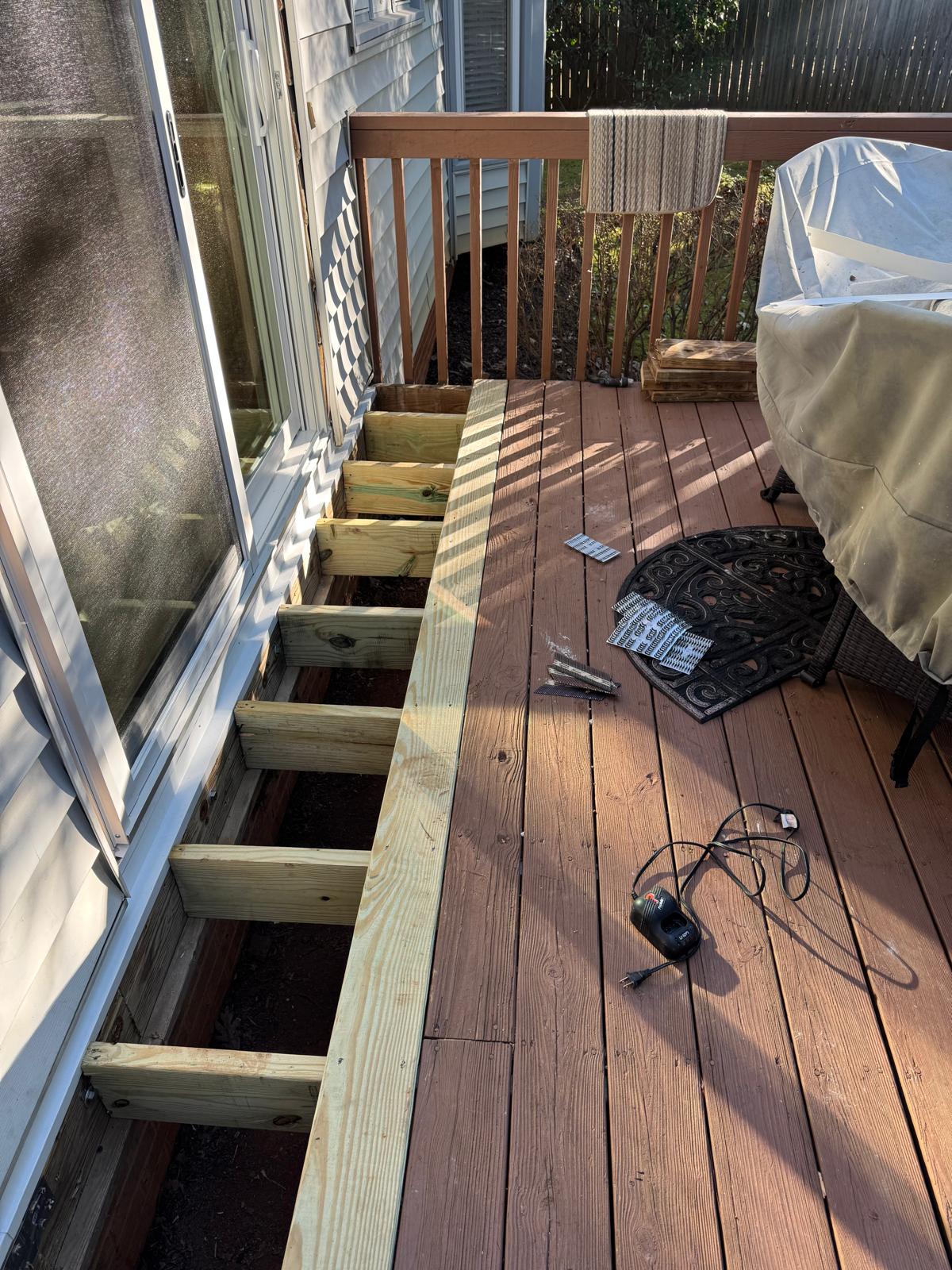 Rotted framing and sill removed at a deck doorway before repair